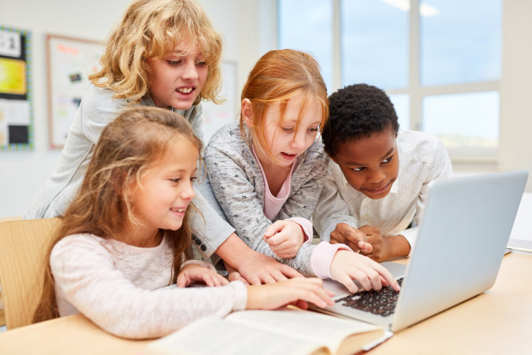 Group of kids at laptop computer learn how to deal with social media